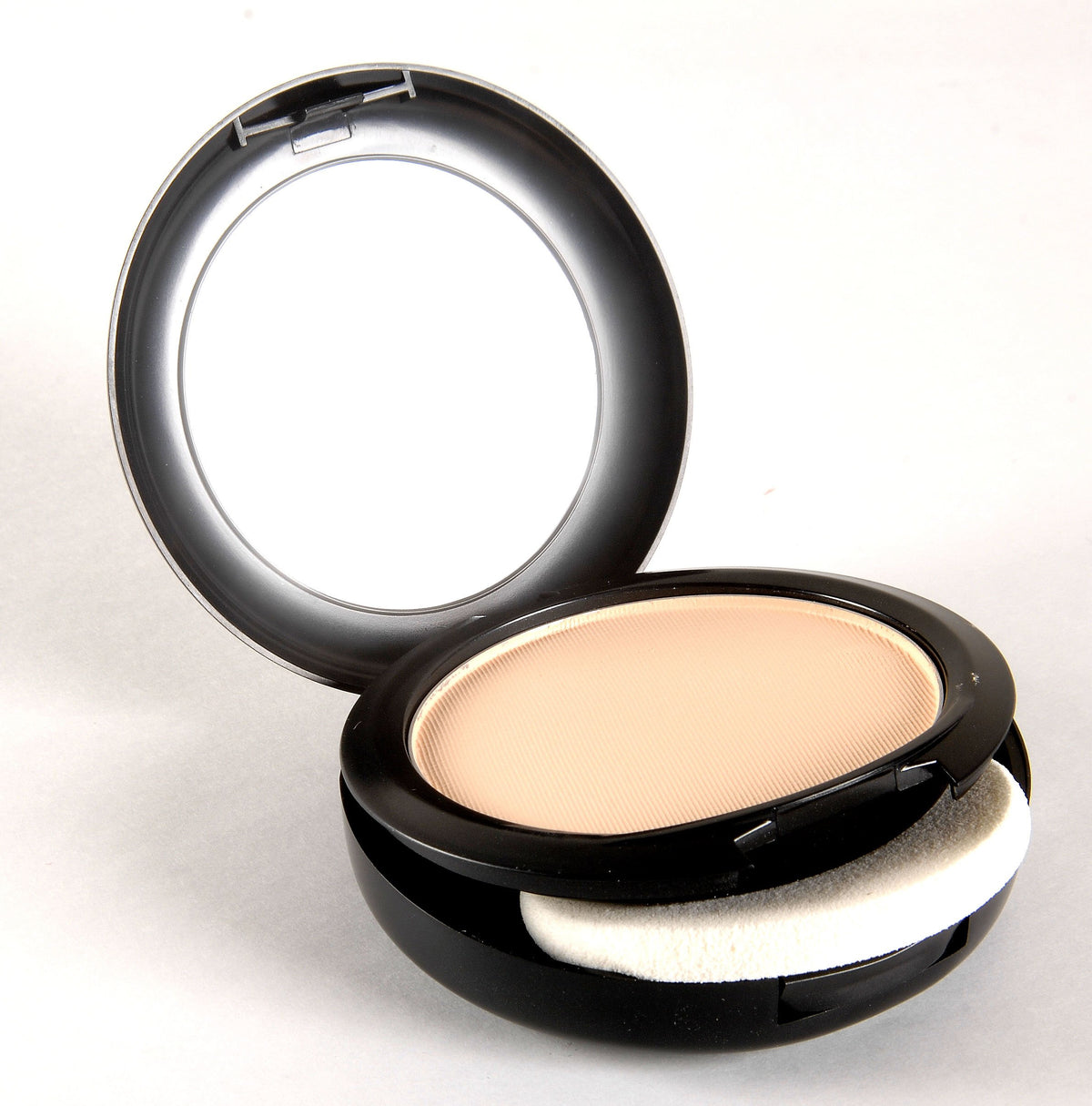 MAC compact with brush in a makeup bag, portable professional finish