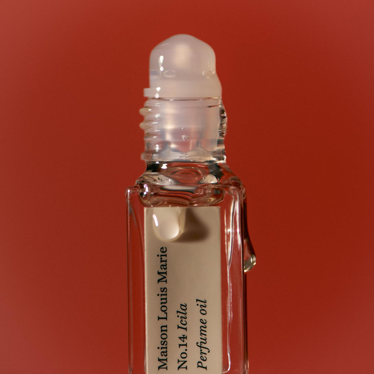Maison Louis Marie Icila roll-on in hand for scale and discreet reapplication convenience