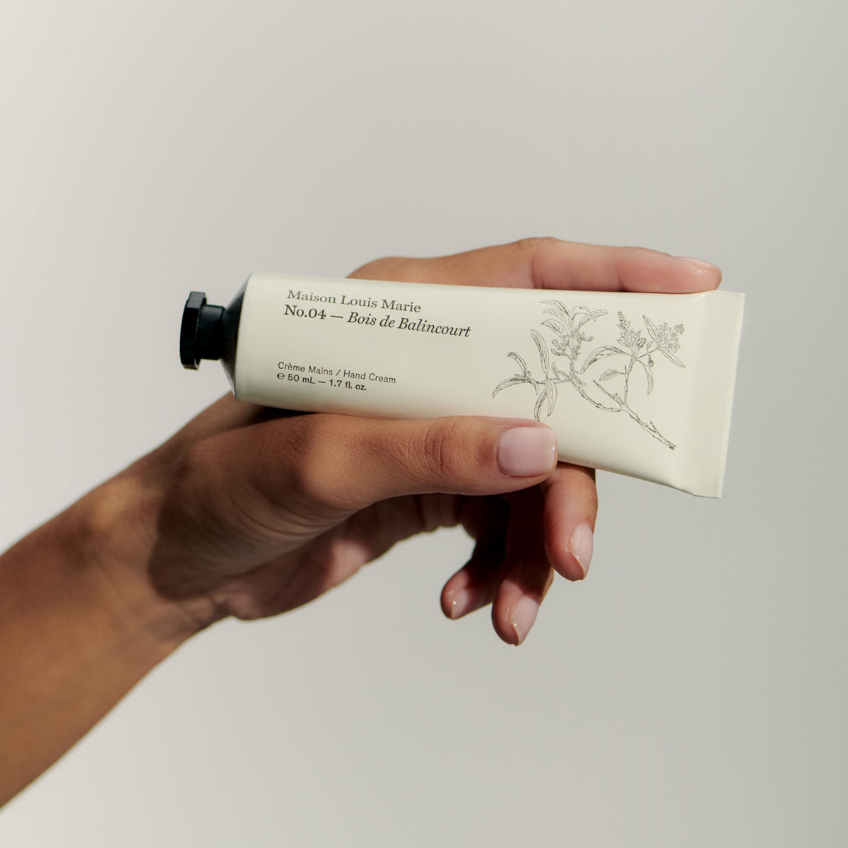 Maison Louis Marie hand applying cream, demonstrates smooth non-greasy finish