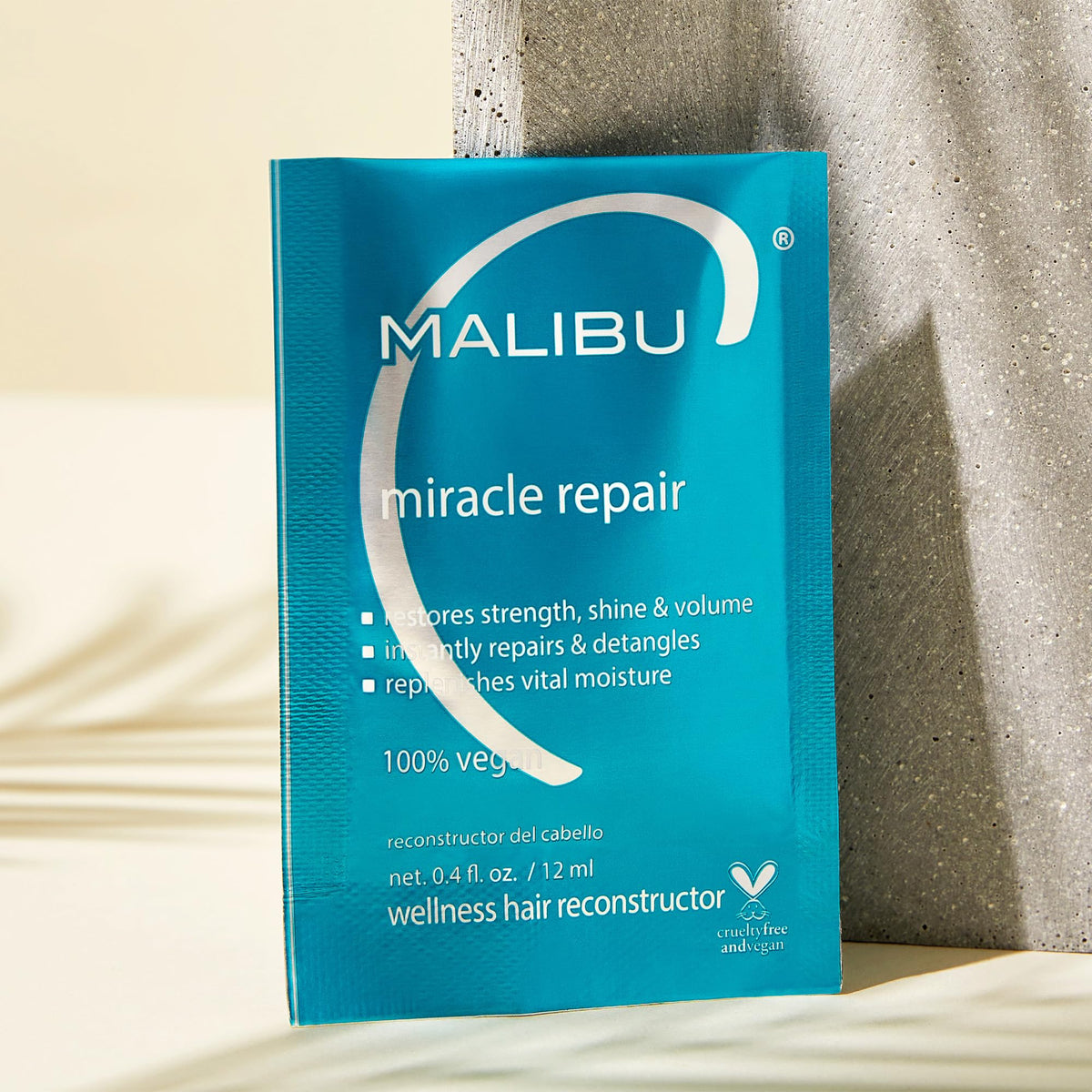 Malibu C being applied through mid-lengths to ends, visibly smoothing hair for manageability