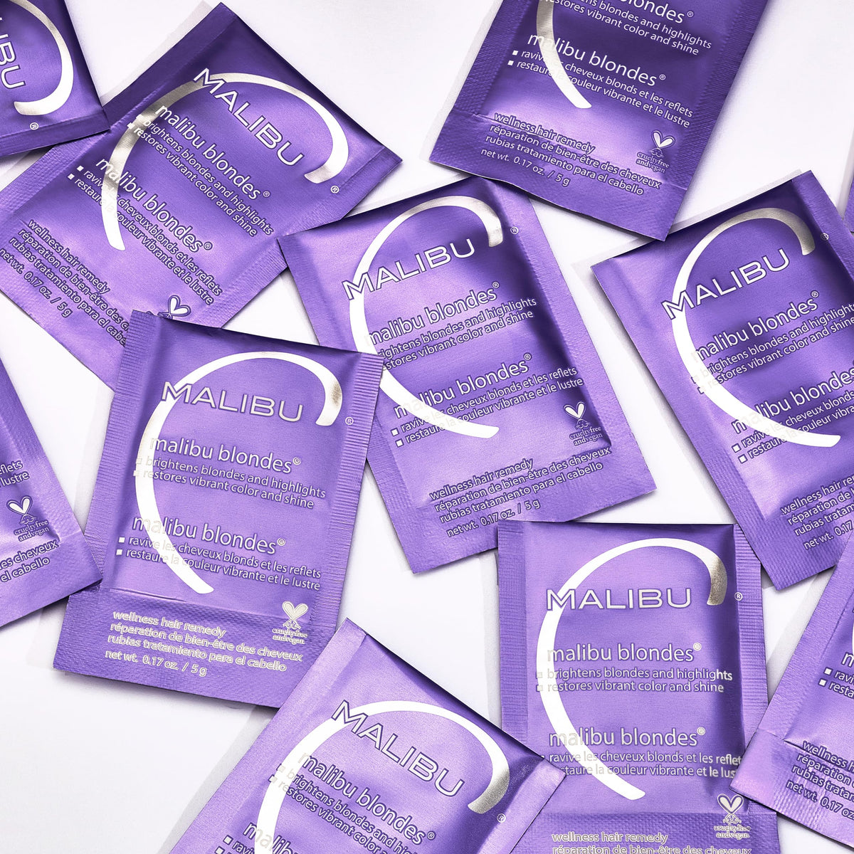 Malibu C packet next to passport illustrating compact, travel-ready hair care