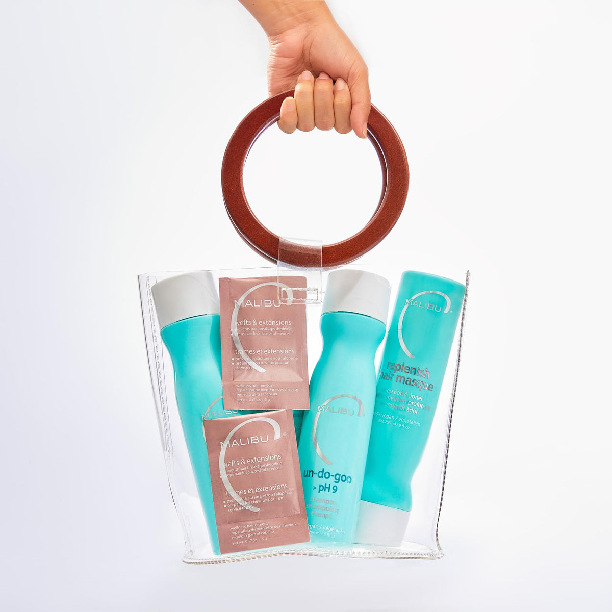 Malibu C bottles for scale in hand illustrating kit size and travel-friendly benefit