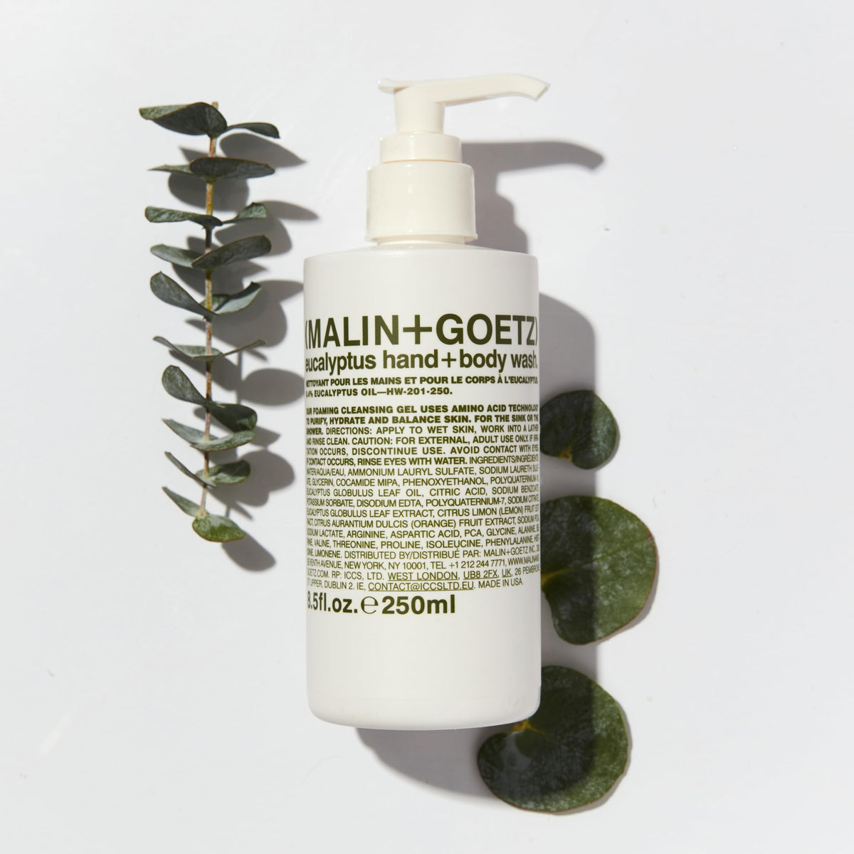 MALIN+GOETZ 8.5 fl oz bottle next to everyday items for size reference