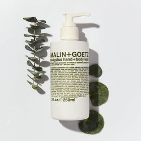 MALIN+GOETZ 8.5 fl oz bottle next to everyday items for size reference