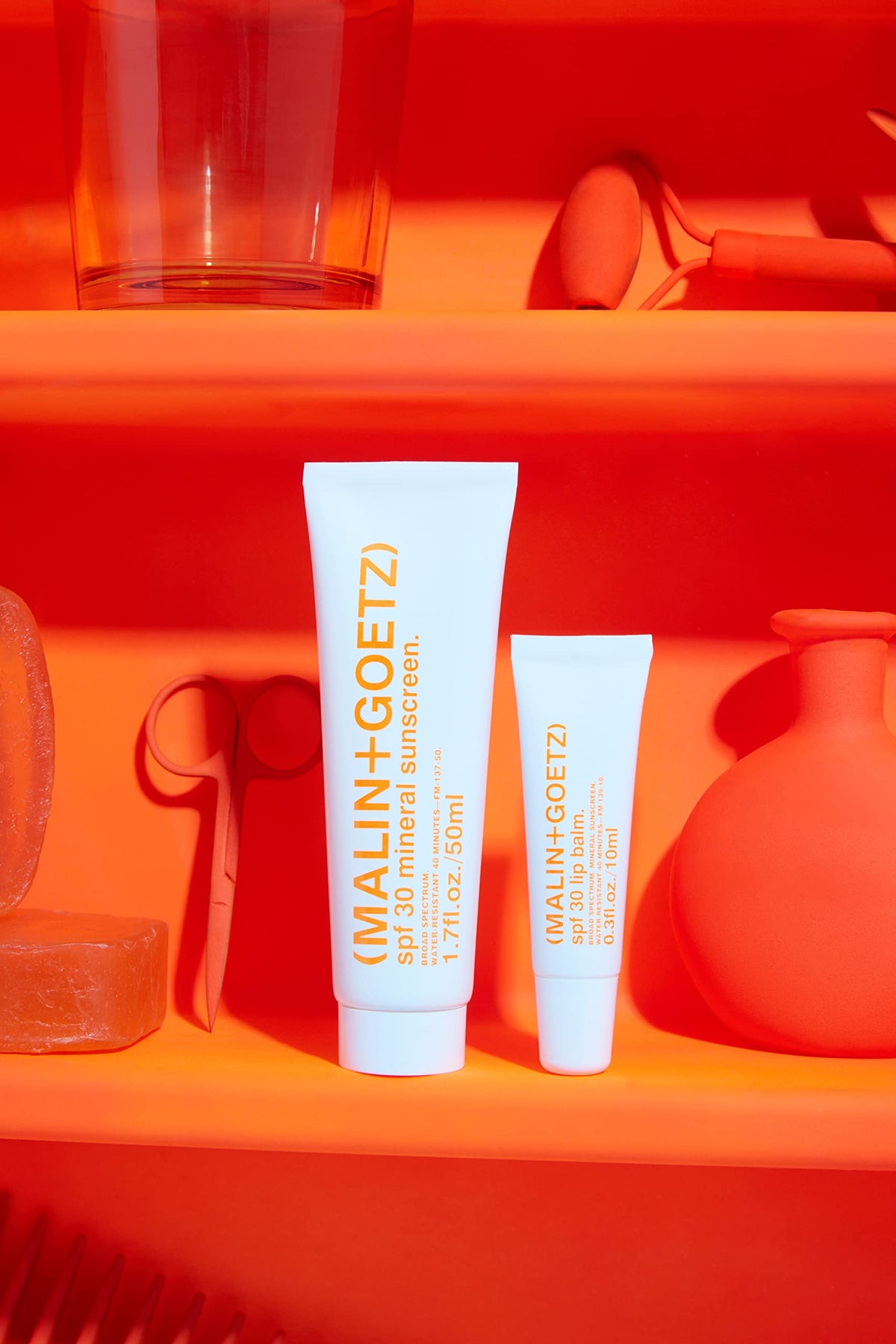 MALIN+GOETZ lip balm in hand demonstrating size and easy on-the-go use