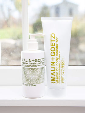 MALIN+GOETZ size comparison with hand showing 16 fl oz scale benefit