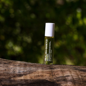 MALIN+GOETZ rollerball in hand indicating small 0.2 fl oz travel-friendly size