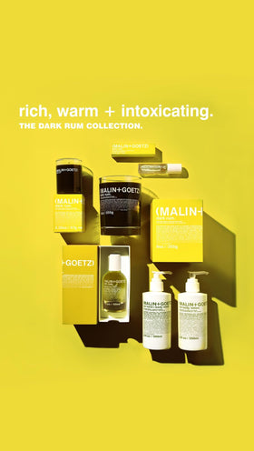 MALIN+GOETZ Dark Rum placed on table in evening setting conveying warm, social vibe