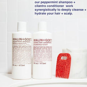 MALIN+GOETZ bottle on bathroom shelf in lifestyle scene suggesting travel-ready use