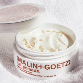 MALIN+GOETZ open tin close-up texture emphasizing firm balm