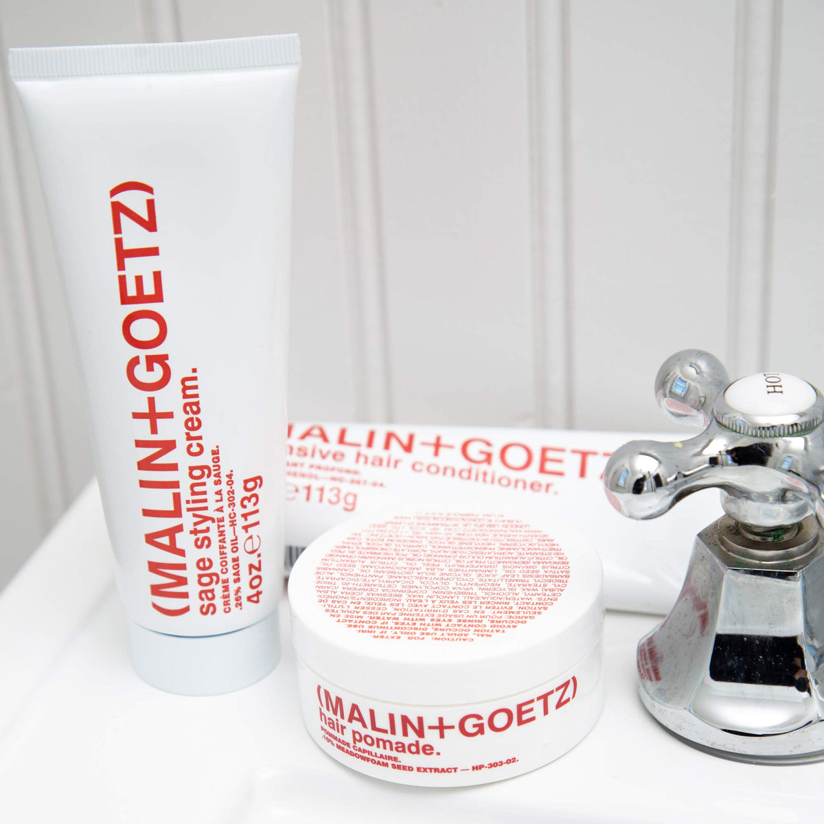 MALIN+GOETZ styling cream tube held in hand for scale and travel-friendly 4 fl oz size