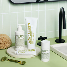 MALIN+GOETZ bottle in shower setting showing daily routine suitability and refreshing scent benefit