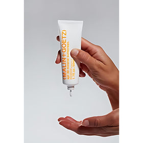 MALIN+GOETZ 1.7 fl oz sunscreen next to hand showing travel-size portability and convenience