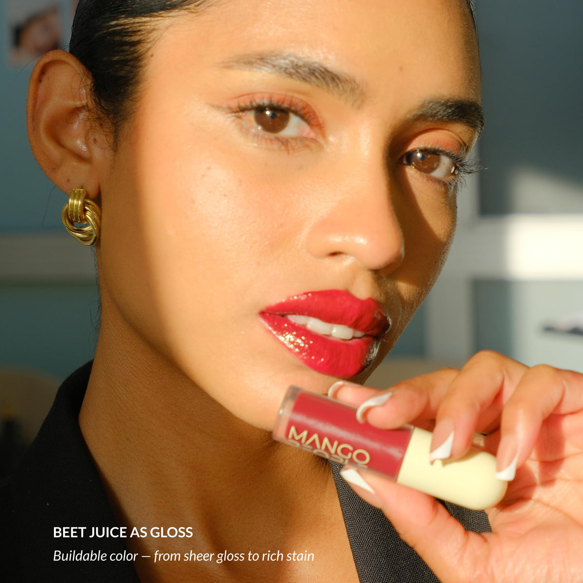 Mango People lip stain held in hand showing product size and portability