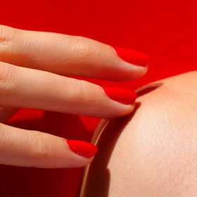 Manucurist swatch on nails demonstrating opaque poppy red coverage