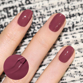 Manucurist swatch on wrist showing true plum shade and opaque coverage