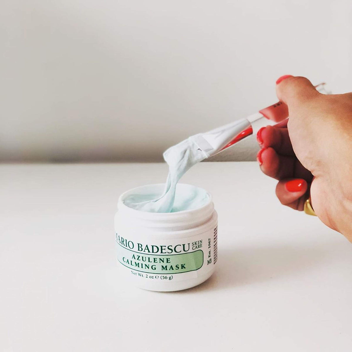 Mario Badescu 2 oz jar beside a coin for scale to show compact travel size