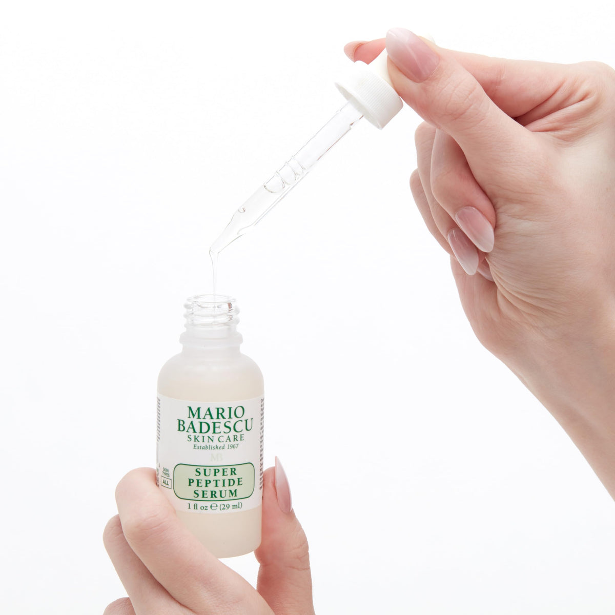 Mario Badescu bottle in hand for scale showing compact 1 fl oz travel-friendly benefit