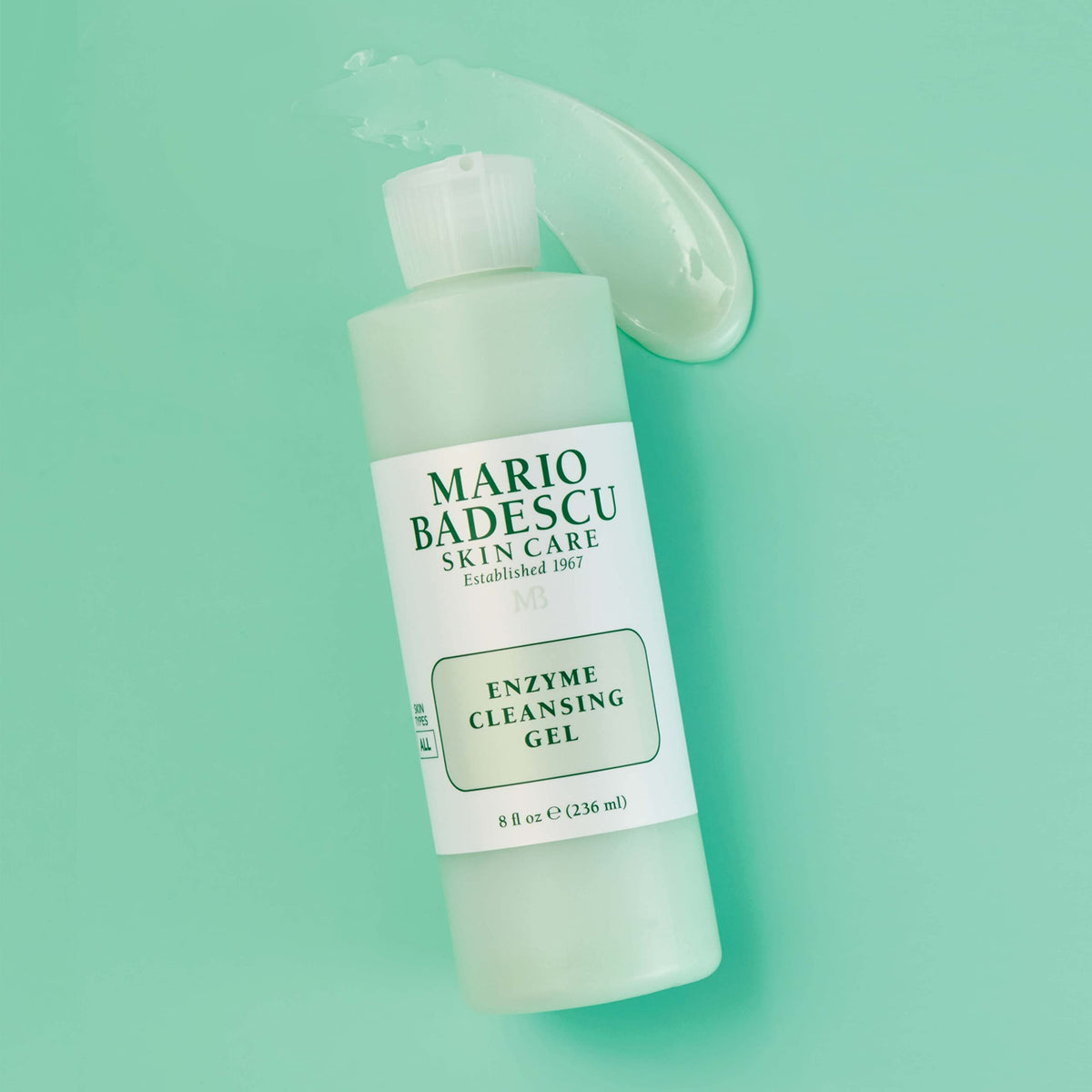 Mario Badescu bottle beside a hand for scale, shows the generous 16 fl oz size