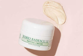 Mario Badescu drying cream next to common items showing compact 0.5 oz travel size