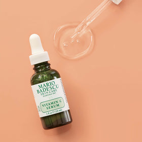 Mario Badescu bottle held in hand showing 1 fl oz scale for size clarity