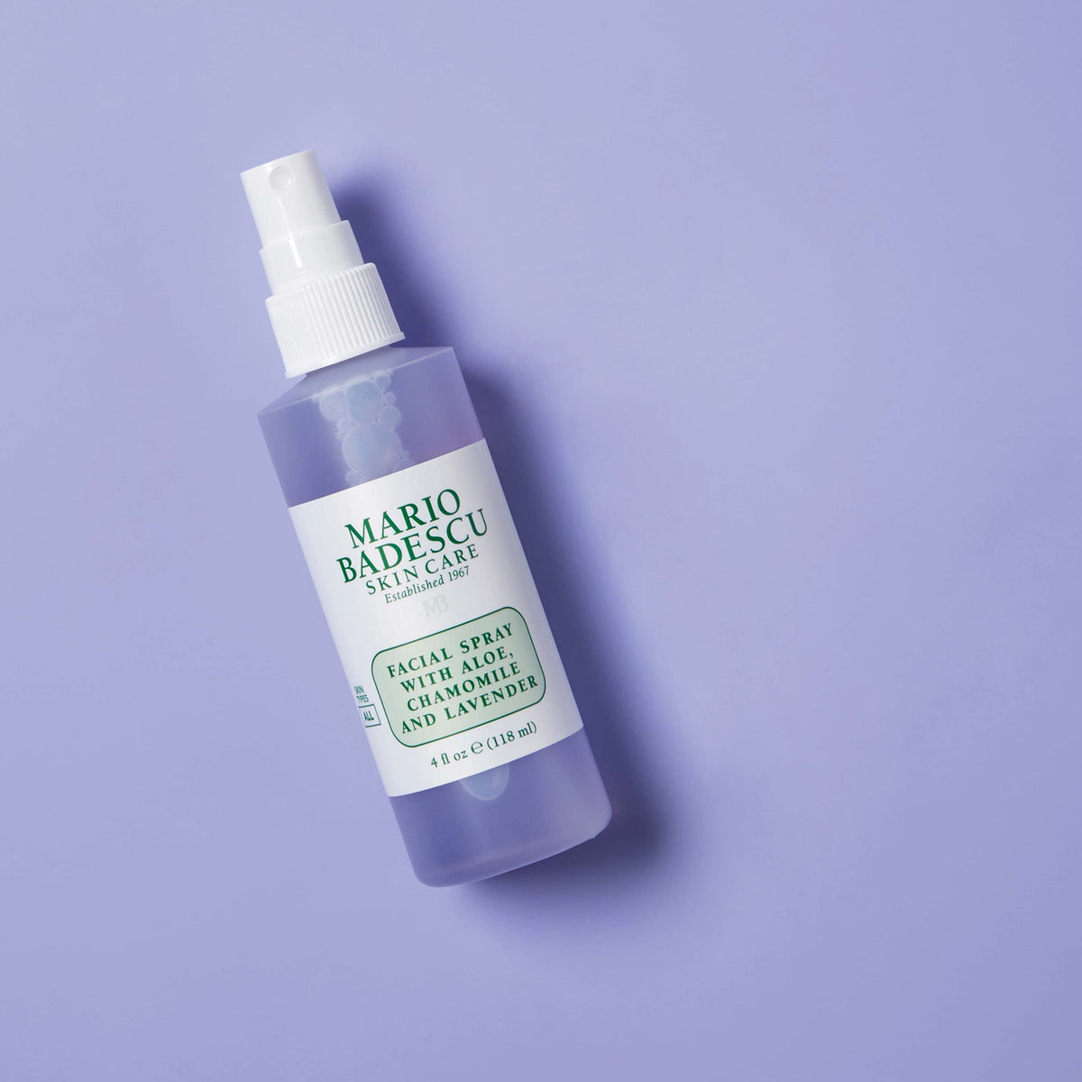 Mario Badescu bottle held in hand to show 4 fl oz size and portability