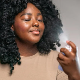 Mario Badescu spray applied to model face, instant refresh and glow benefit
