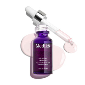 Medik8 1 oz bottle next to a coin for scale showing travel-friendly size