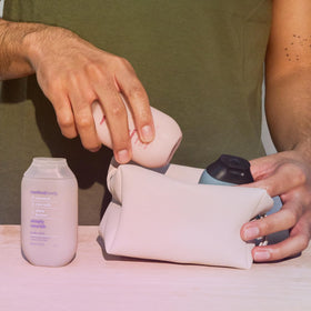 Three Method travel bottles next to a passport showing compact, TSA-friendly convenience