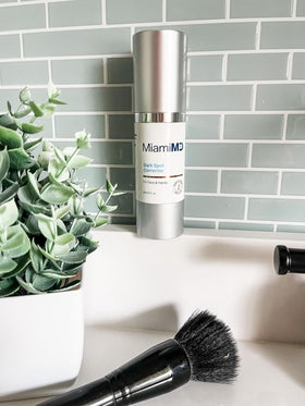MiamiMD bottle on vanity with towel and plants conveying daily skincare ritual