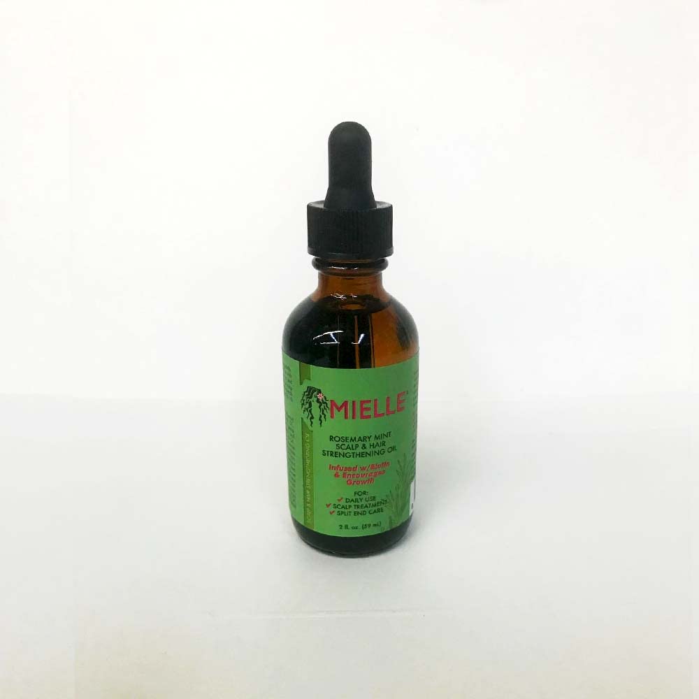 Mielle Organics strengthening oil drops on fingertip showing nourishment and split-end protection benefit