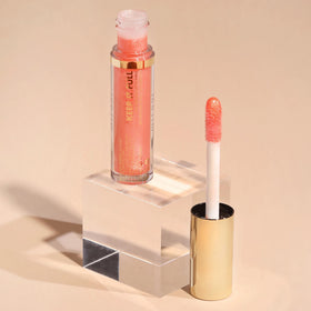 Milani gloss on vanity being applied for on-the-go refresh and polished look benefit