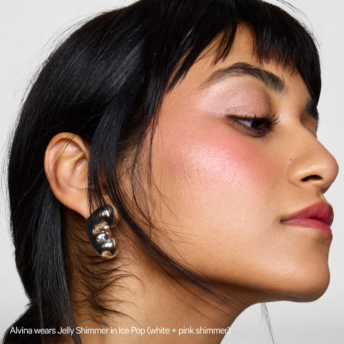 Milk Makeup highlighter on model cheekbone showing natural radiant finish benefit