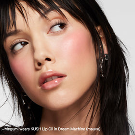 Milk Makeup KUSH on lips in lifestyle shot offering wearable shine and everyday style appeal