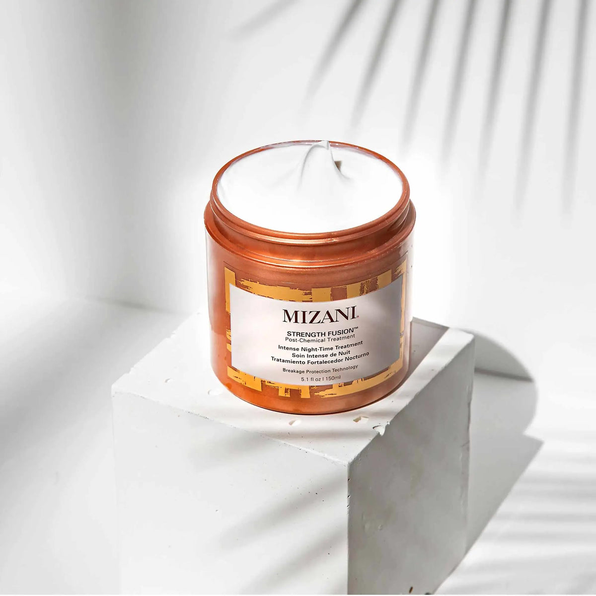 Mizani in-use on curly hair overnight demonstrating strengthened, smoother strands