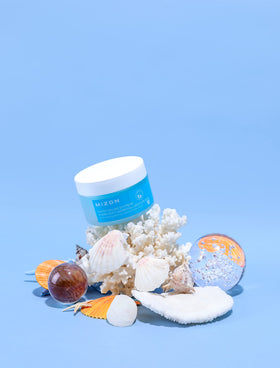 MIZON cream on fingertips demonstrating easy spreadability benefit