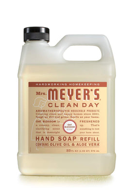 Mrs. MEYER'S Oat Blossom refill beside blossoms highlighting soft floral scent