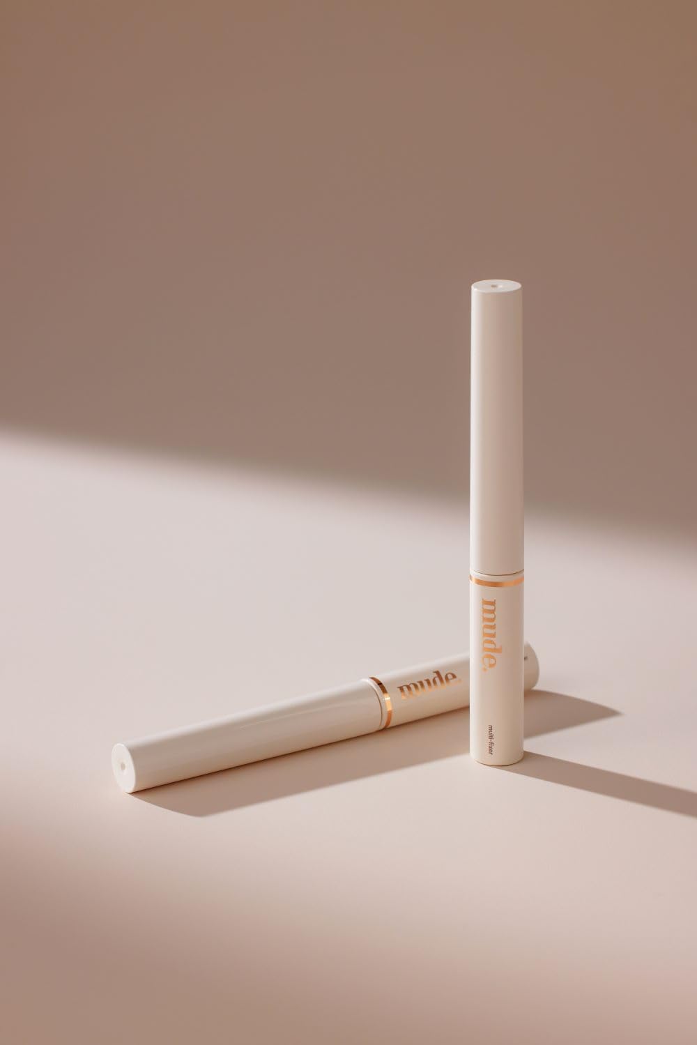 mude size comparison in hand indicating portable, travel-friendly tube