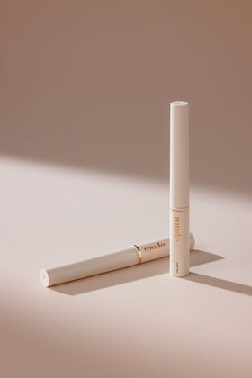 mude size comparison in hand indicating portable, travel-friendly tube
