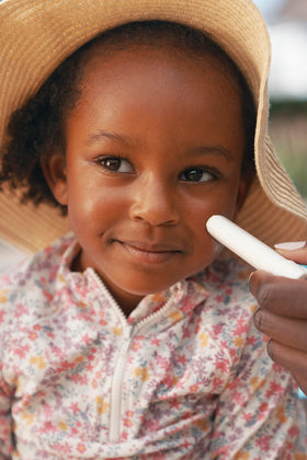 Mustela stick in hand scale showing portable size for quick reapplication