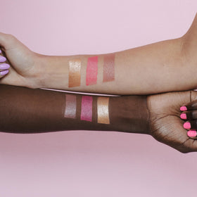 Naked Sundays held in hand for scale, compact travel-friendly sunscreen balm