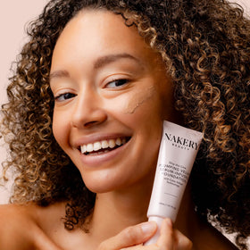 Nakery foundation on bathroom counter beside mirror showing daily routine ease and streamlined setup