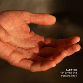 Naomi Cooking bottle beside a hand for scale showing travel-friendly size benefit