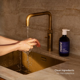 Naomi bottle held by hand next to utensils to show true size and scale