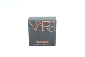 NARS model applying bronzer to cheeks illustrating natural warmth benefit