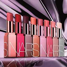 NARS Orgasm Afterglow Lip Balm next to a coin showing size and portability benefit