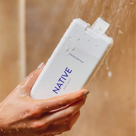 Native bottles next to hand for scale showing travel and convenience benefit