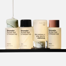 Nécessaire four travel body wash bottles lined up for comparison and convenient travel