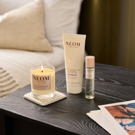 Neom body butter scooped into palm demonstrating rich texture and easy absorption