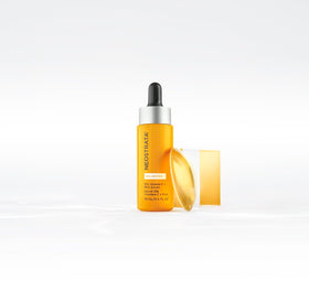 NEOSTRATA small 0.5 fl oz bottle next to a coin for size comparison
